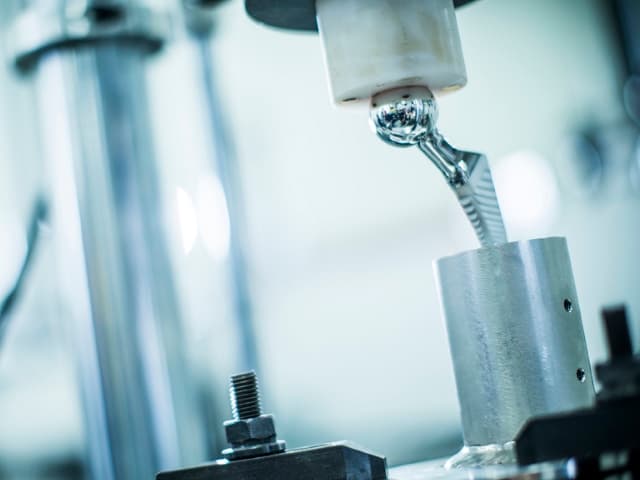 Two testing engineers standing together in Element medical device testing laboratory with specialized equipment around them