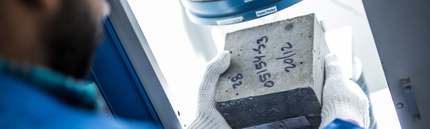 Building materials testing engineer holding a concrete sample
