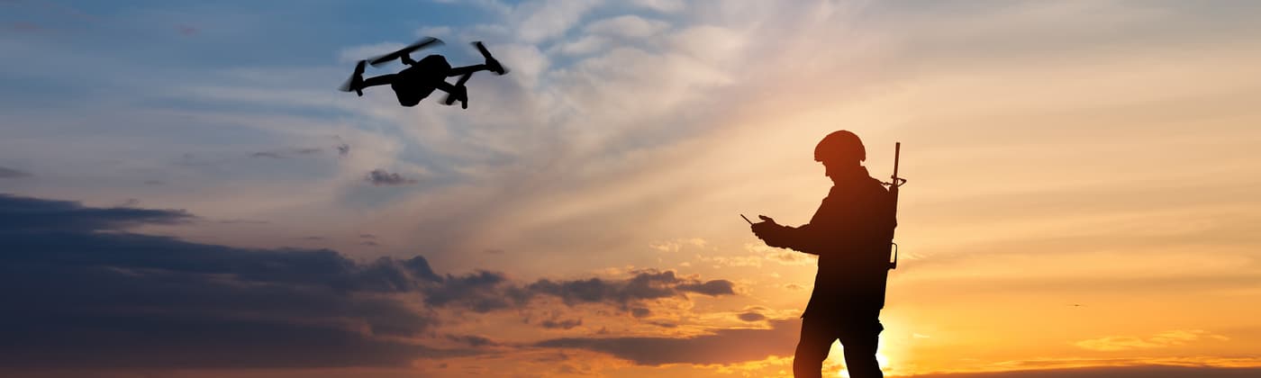 Service member in front of a sunset background operating drone that has undergone military and aerospace component certification