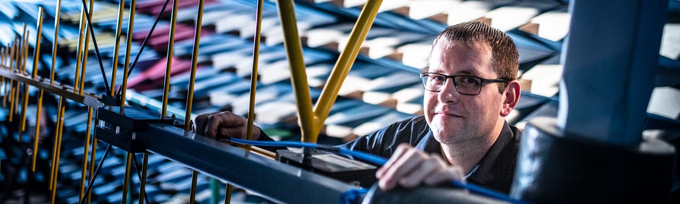 Testing engineer in an anechoic chamber with EMC testing equipment