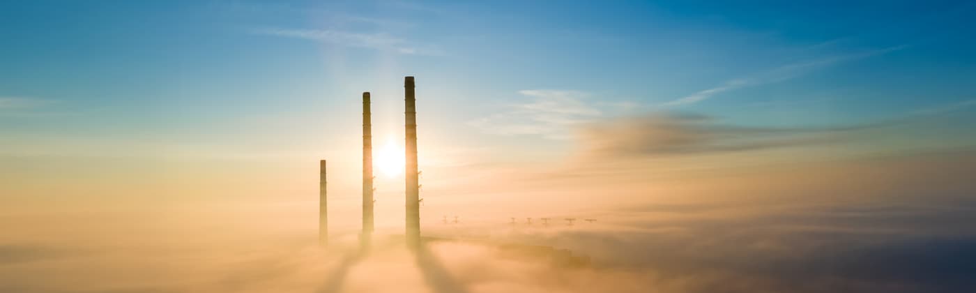 Energy nuclear power plant smokestacks rising up out of clouds