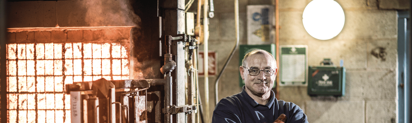 Element fire and flammability testing engineer standing in front of test frame glowing from high-temperature fire testing