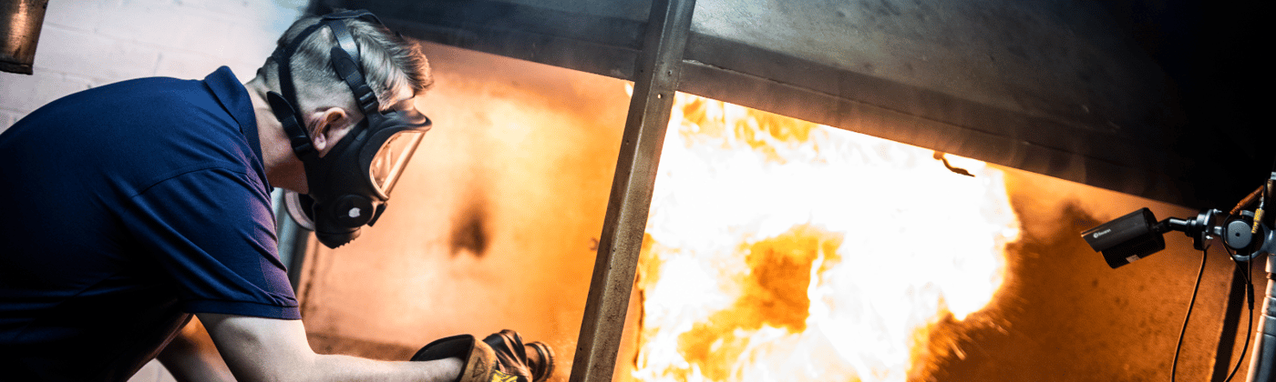 Element fire testing services engineer observing controlled burn test for building materials safety