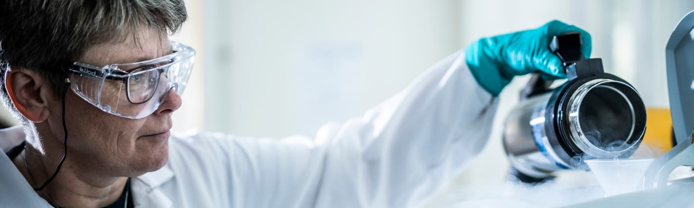 Element materials testing specialist examining sample with protective equipment for quality analysis