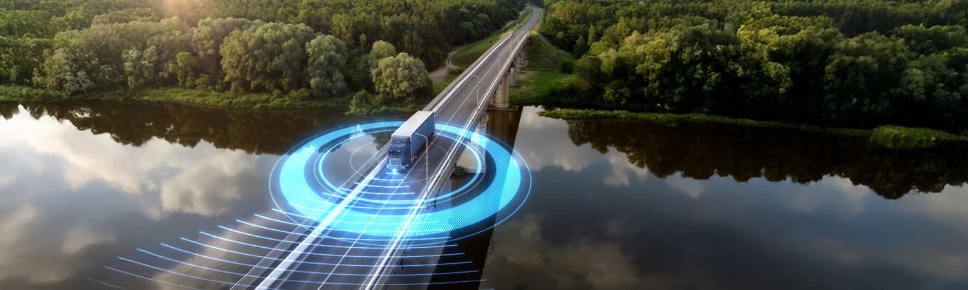 Autonomous truck with digital sensor overlay on bridge representing transportation testing and connected vehicle certification