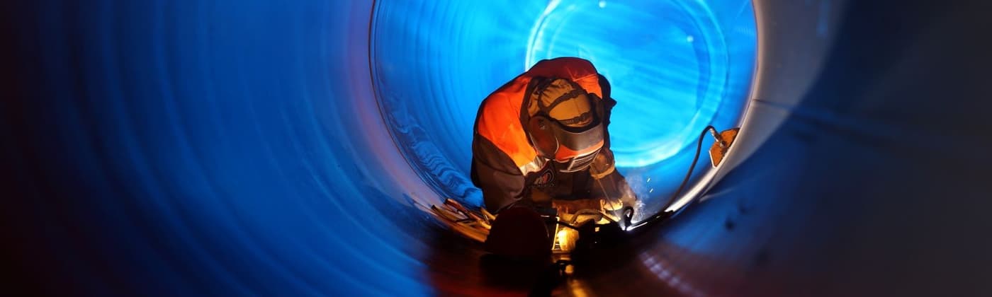 Welding professional welding in a subsea pipeline wearing protective equipment