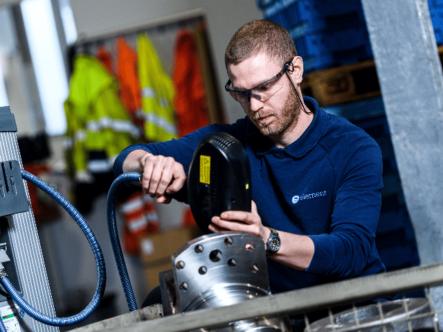 Element testing engineer operating specialized equipment for metal component analysis